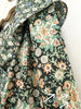 Floral fabric with green, orange, and white flowers on a black background